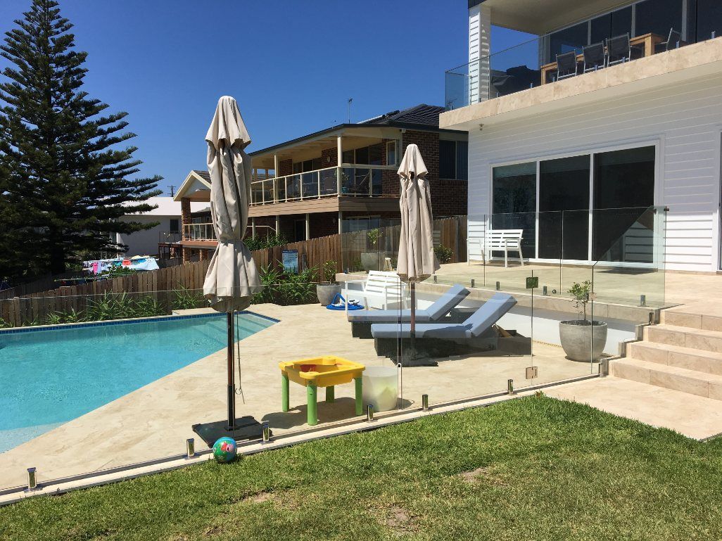 A Large House with A Swimming Pool in Front of It — Lifestyle Aluminium Fabrication In Albion Park Rail, NSW