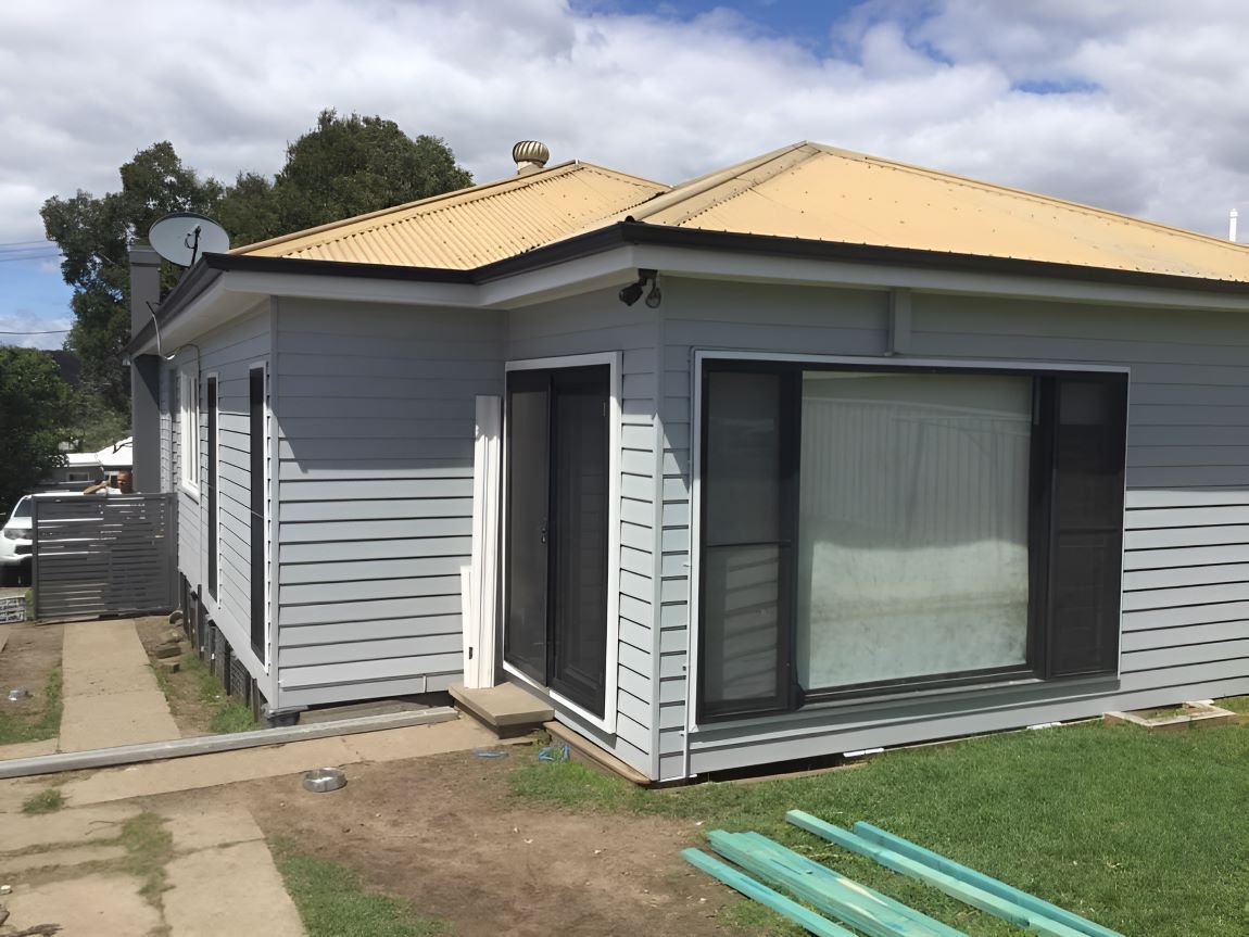 A House With A Yellow Roof And A Satellite Dish On Top Of It — In-Time Roofing In Newcastle, NSW