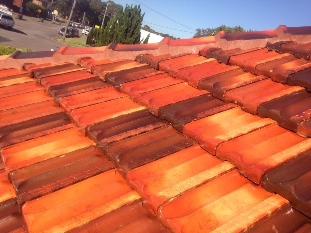 A Close Up Of A Roof With Red And Brown Tiles — In-Time Roofing In Newcastle, NSW