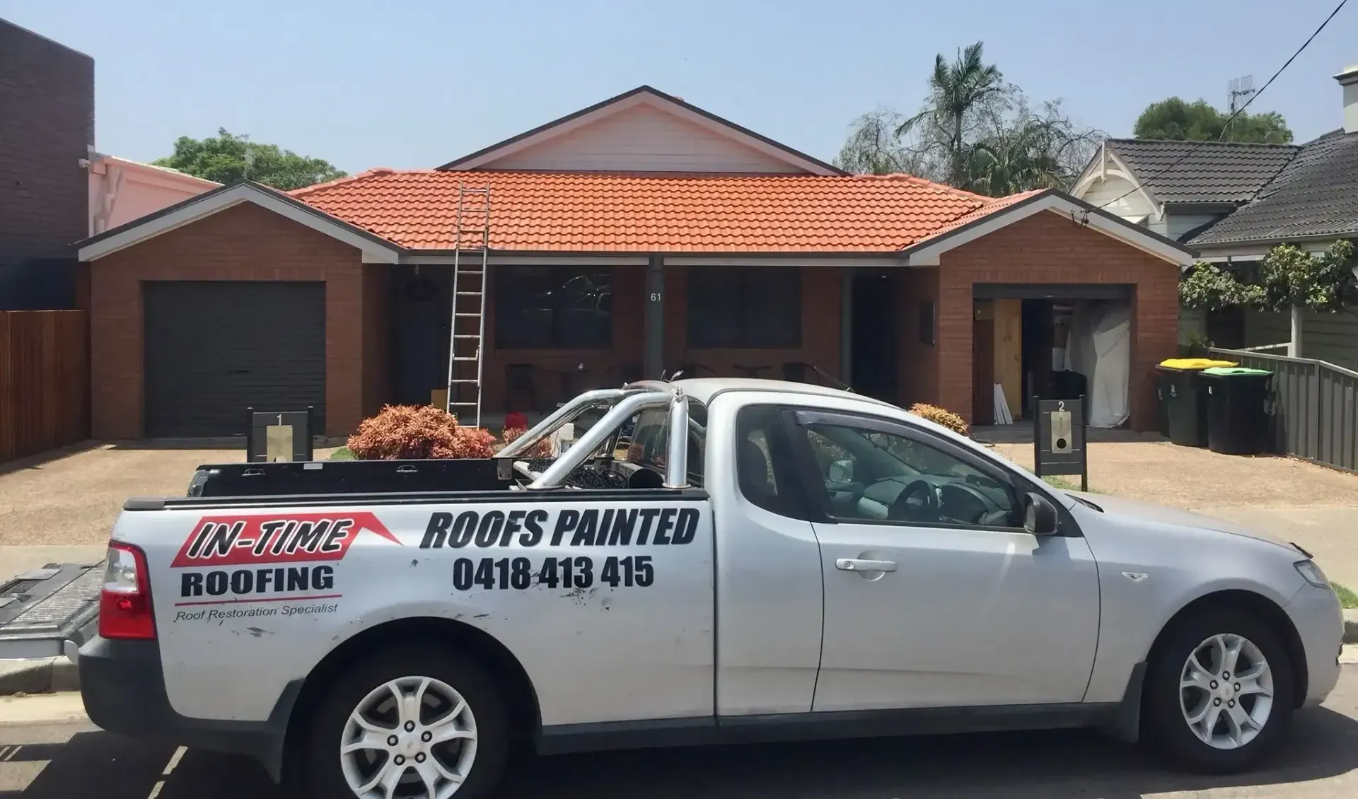 A Roofs Painted Truck Is Parked In Front Of A House — In-Time Roofing In Newcastle, NSW