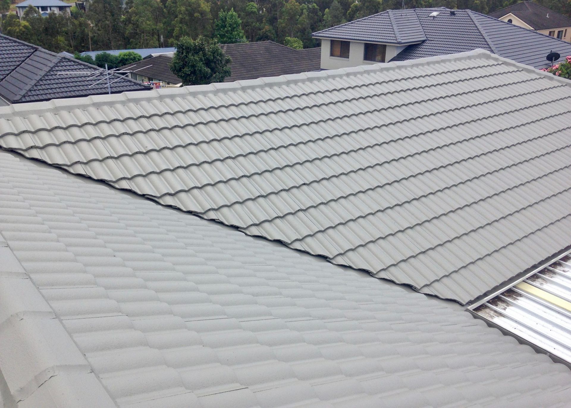A Roof Of A House With A Gray Tile Roof — In-Time Roofing In Newcastle, NSW