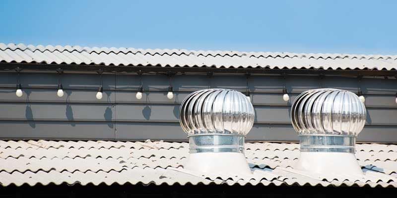 Two Wind Turbines On The Roof Of A Building — In-Time Roofing In Newcastle, NSW