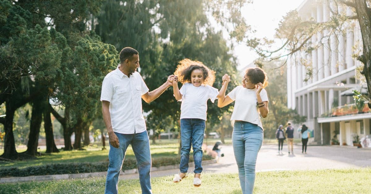 family enjoying playing with 
their child in a park
