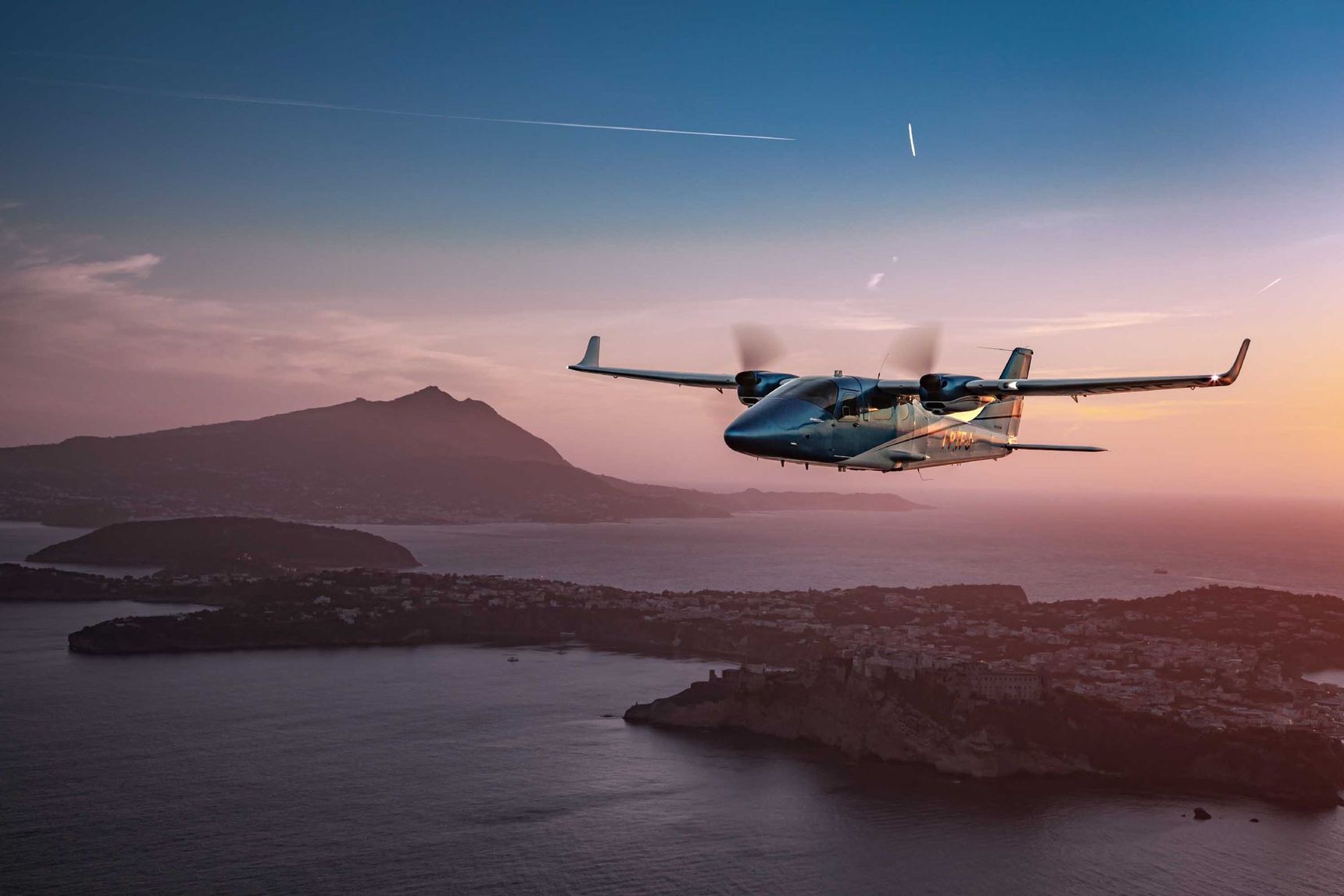 Twin-engine aircraft flying over mountains during scenic training flight.
