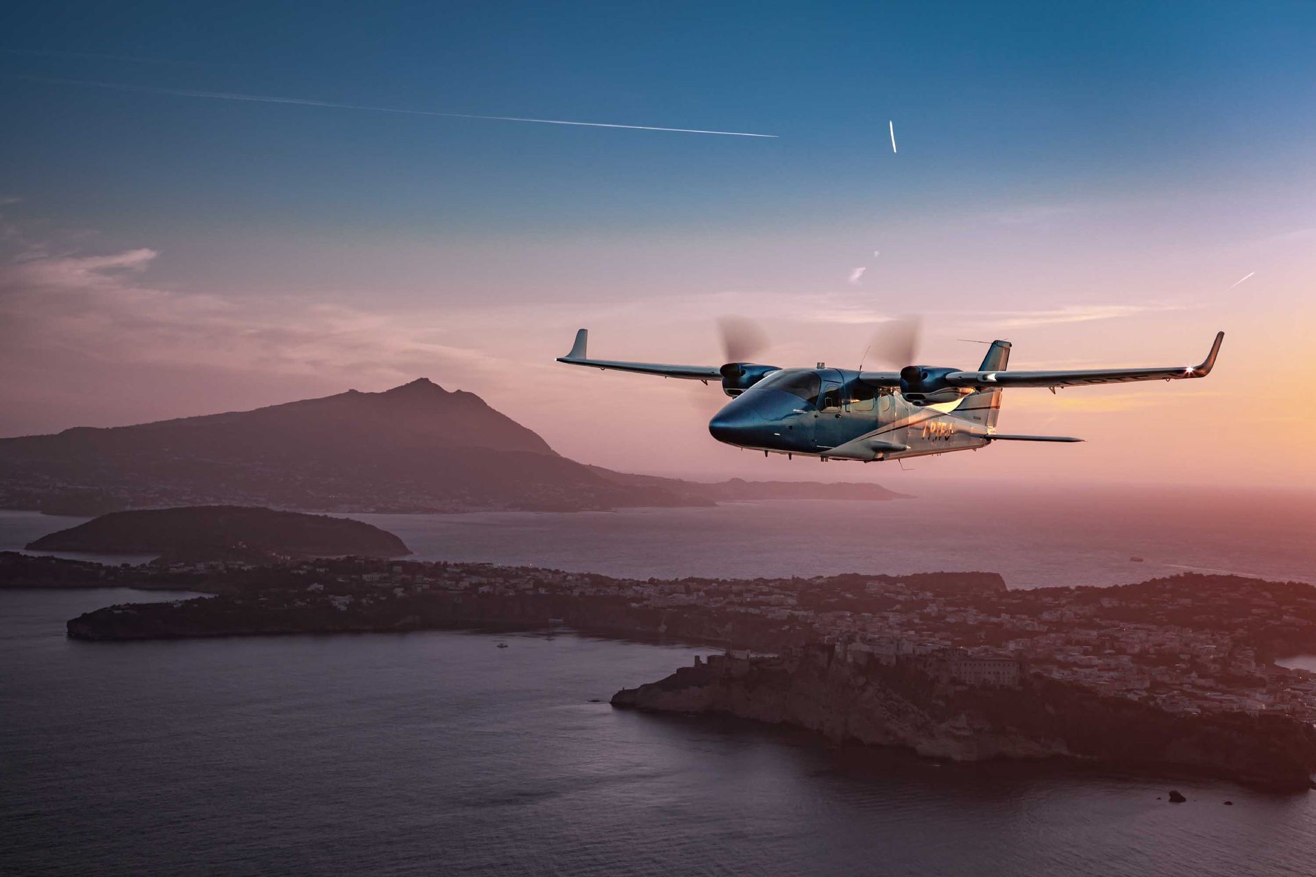 Twin-engine aircraft flying over mountains during scenic training flight.