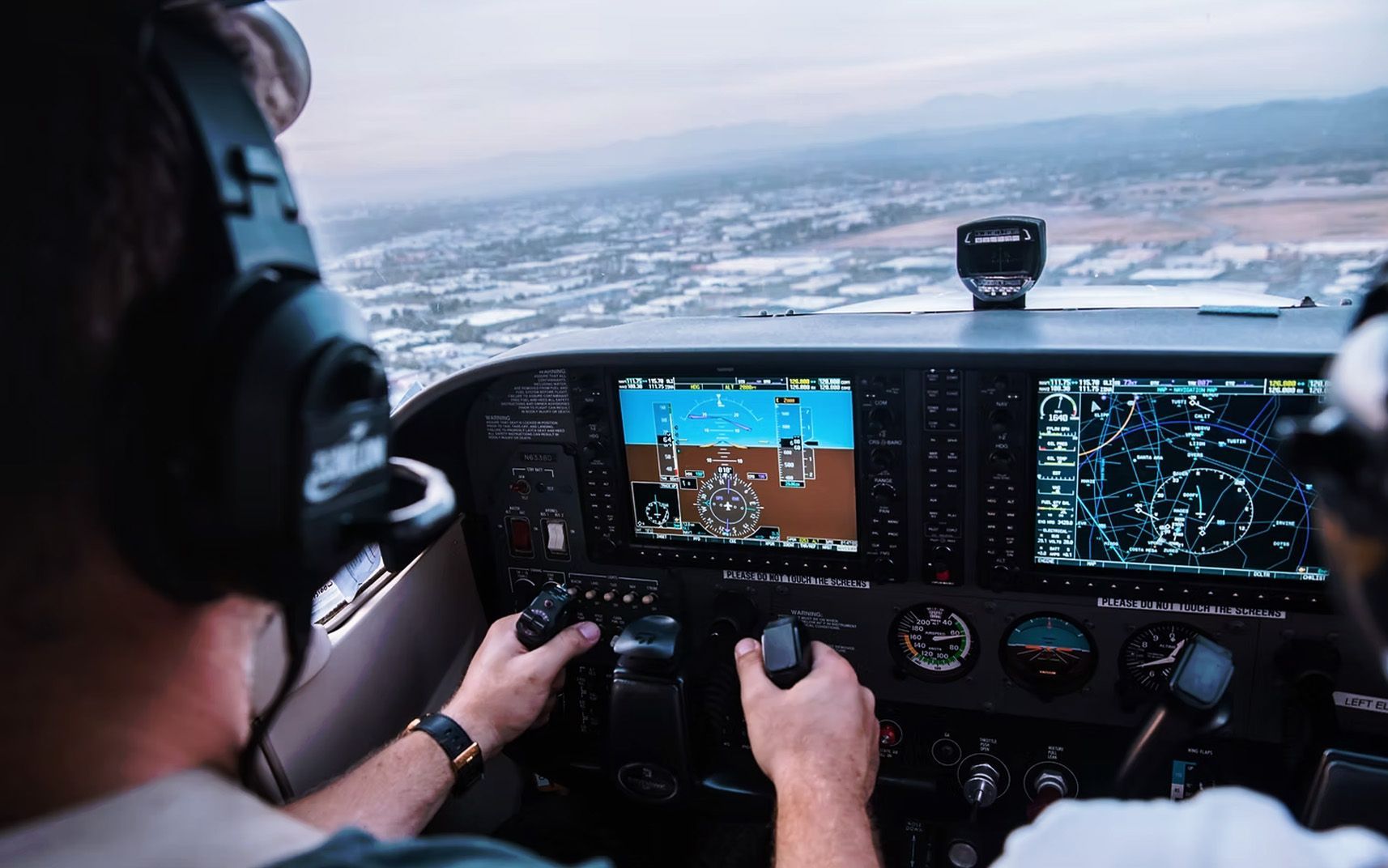 Pilot flying a small aircraft with full instrument panel visible.