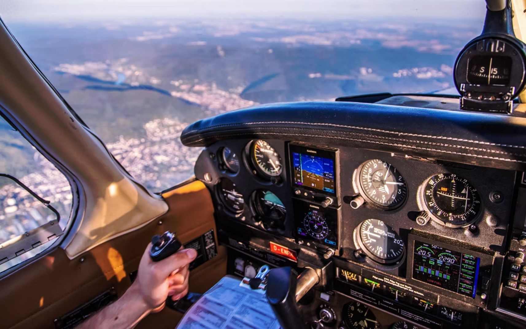 Student pilot operating aircraft with full cockpit instrument panel visible.