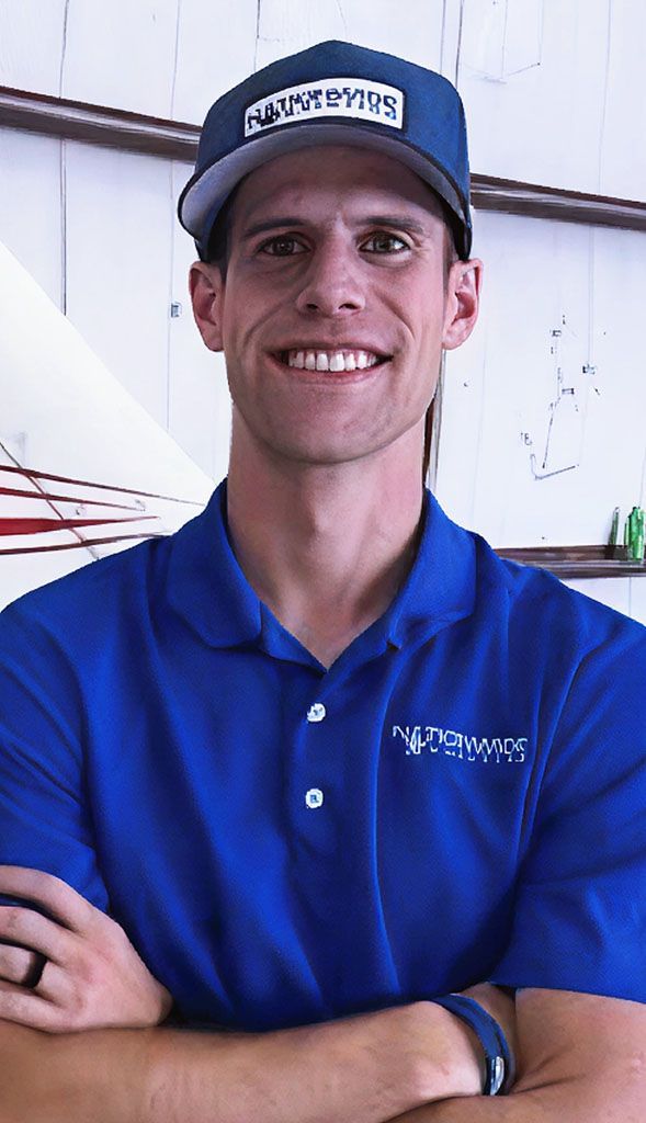 Student standing outdoors wearing aviation cap for testimonial.