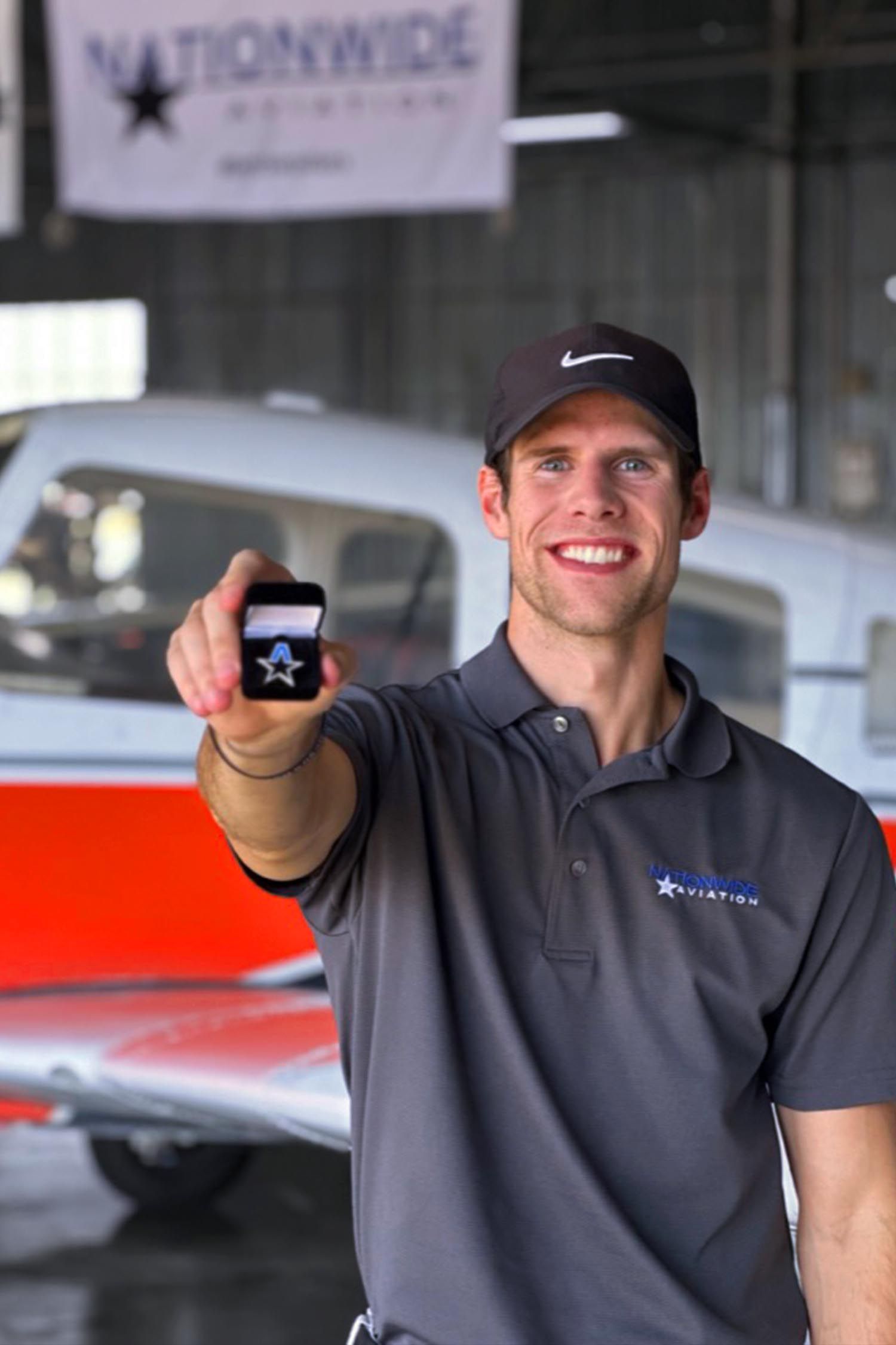 Student smiling inside aircraft hangar for accelerated program testimonial.