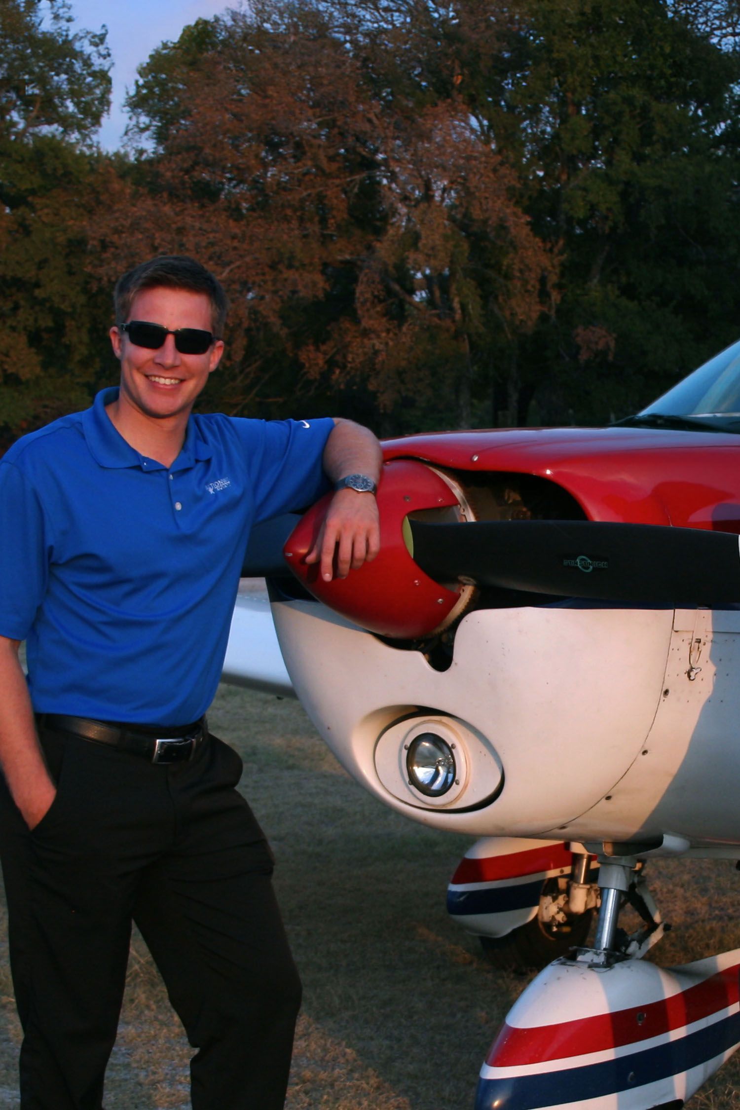 Student standing outdoors beside aircraft during training.