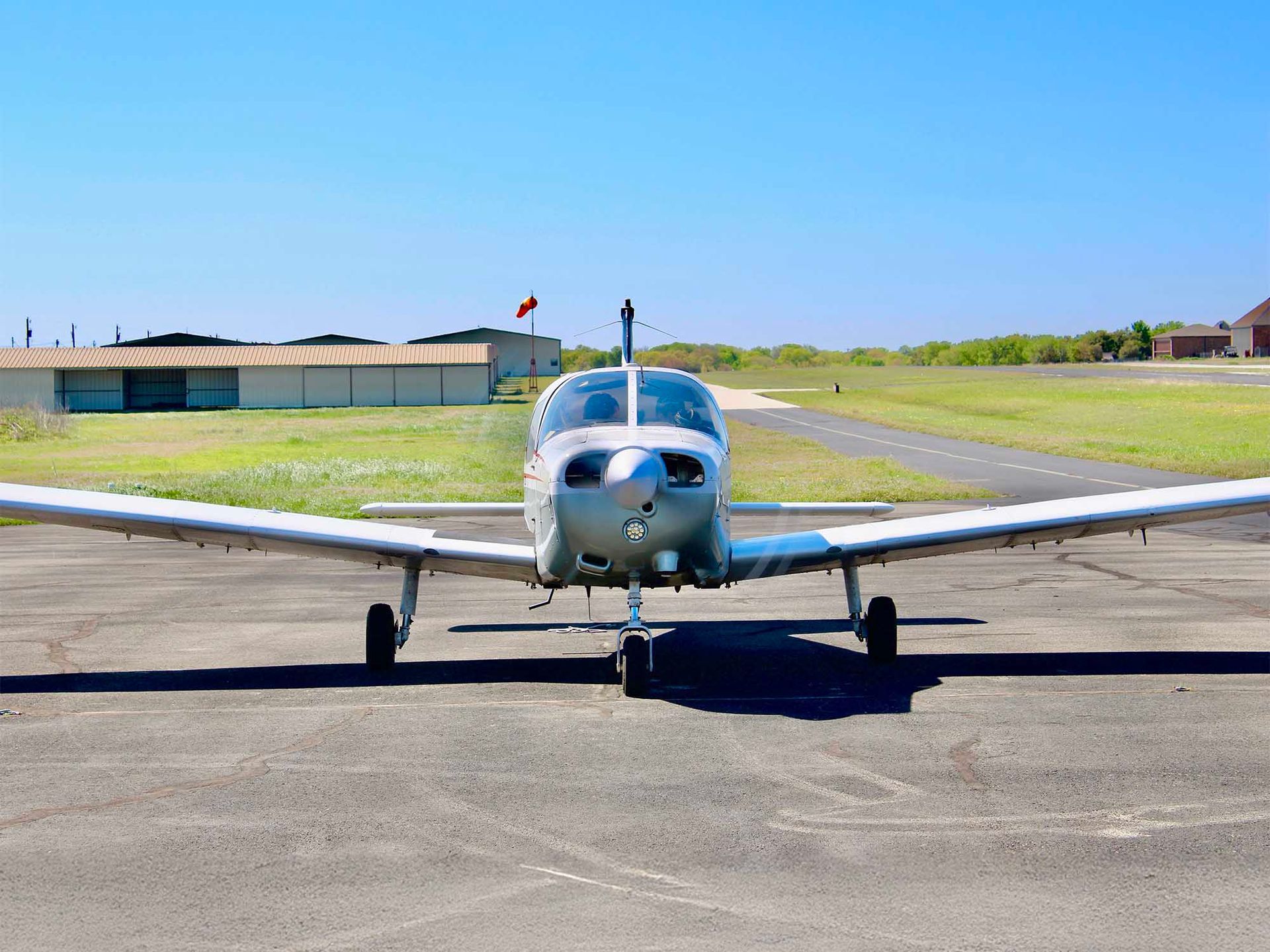 Single-engine aircraft parked on the runway ready for student pilot training.