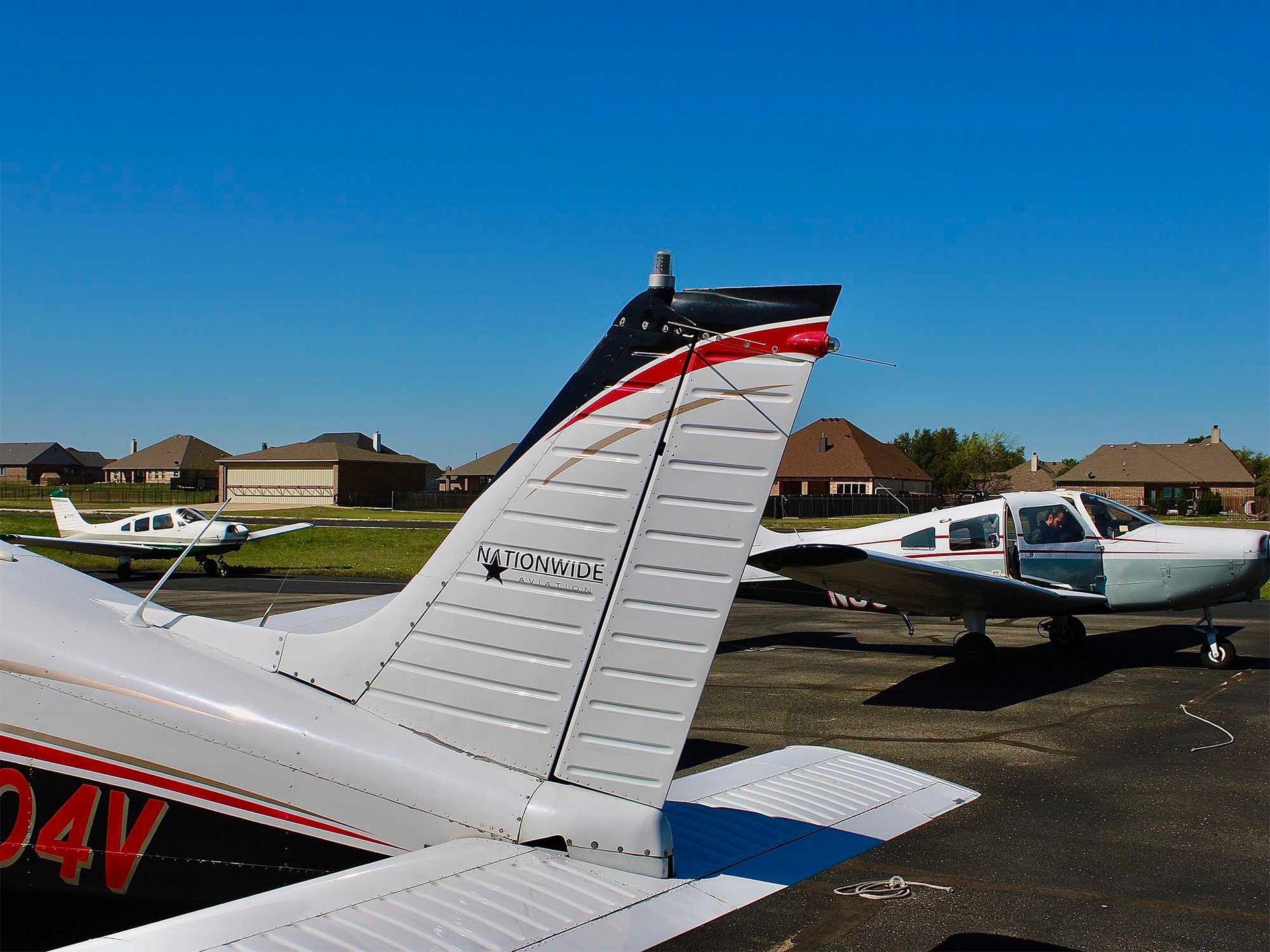 Aircraft lined up on the ramp with a close-up of a tail section.