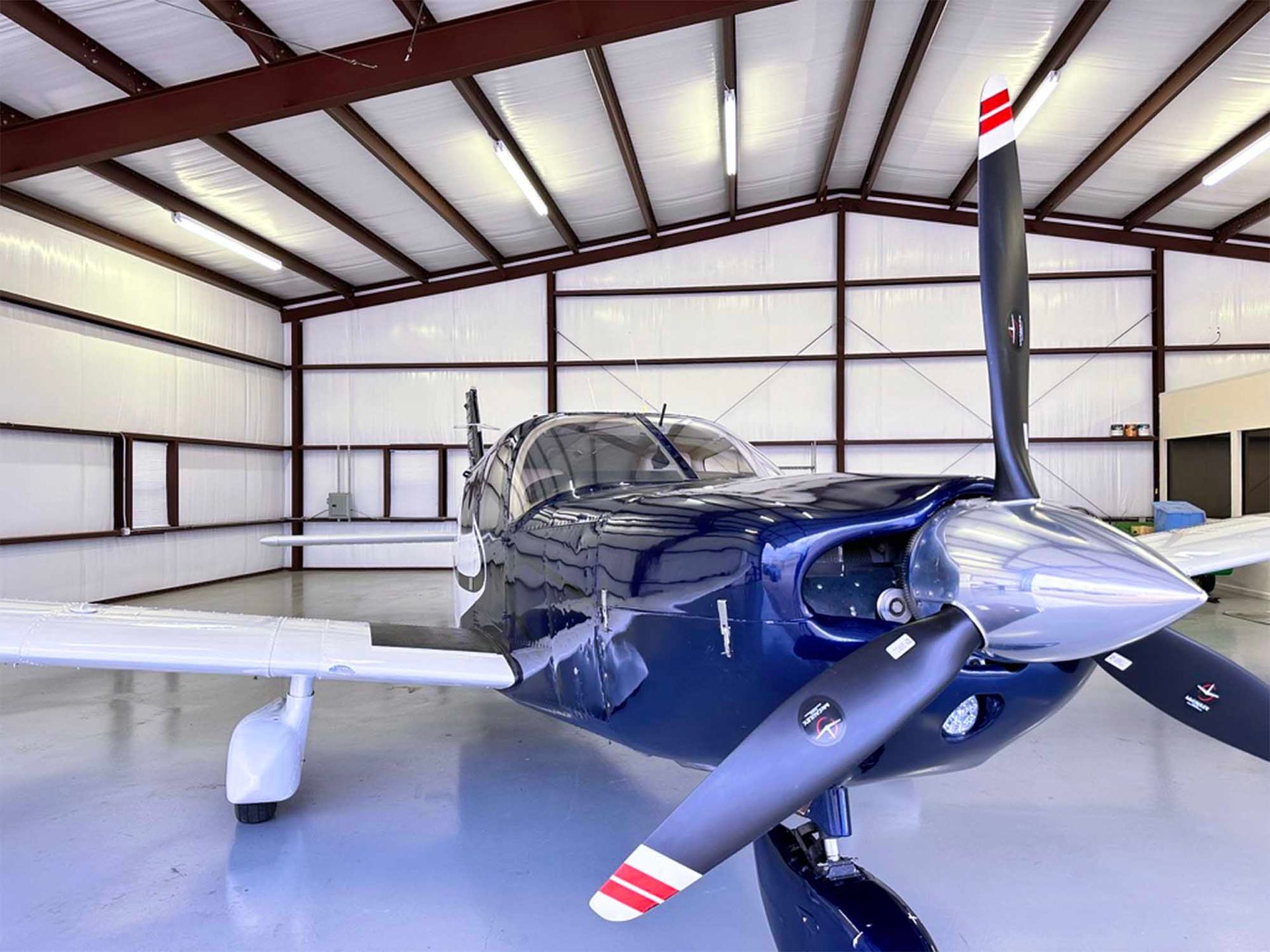 Twin-engine aircraft inside a hangar prepared for pilot training flights.