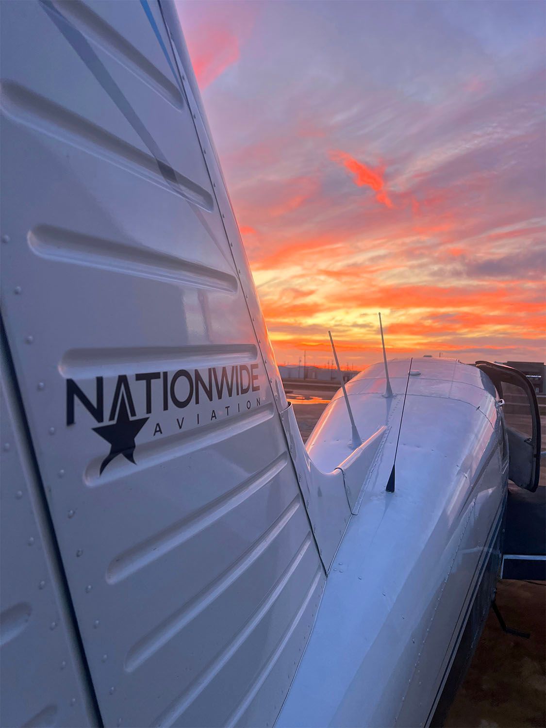 Airplane wing at sunset captured from the ramp before a training flight.