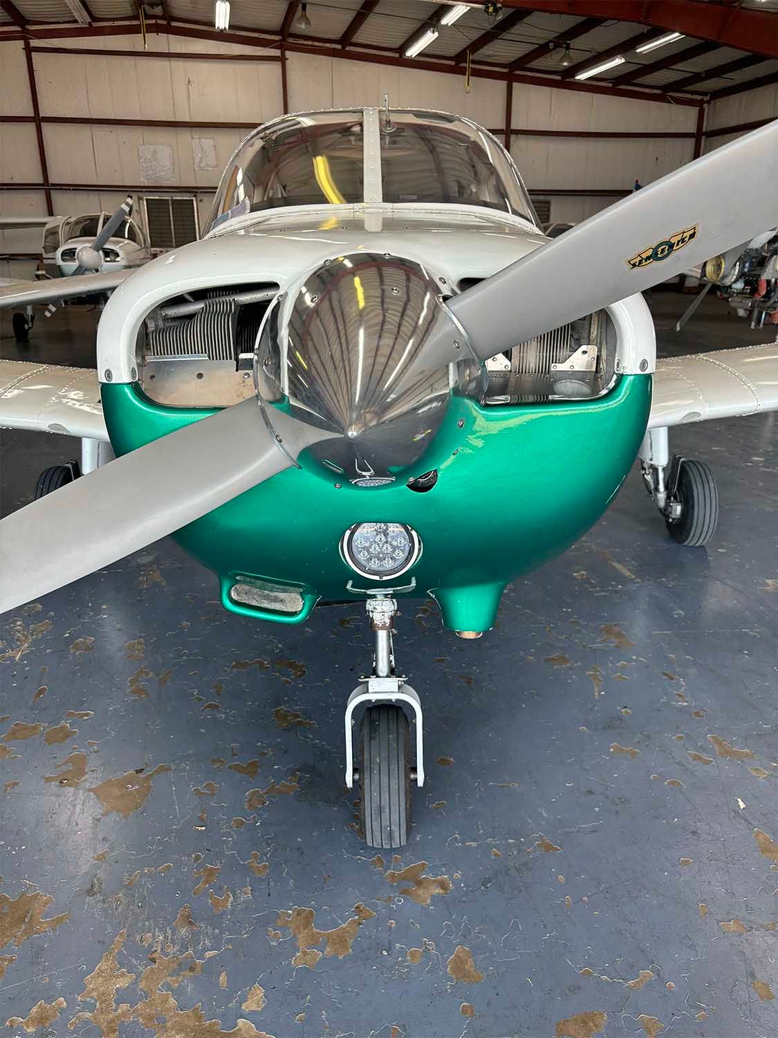 Single-engine training aircraft parked inside a hangar.
