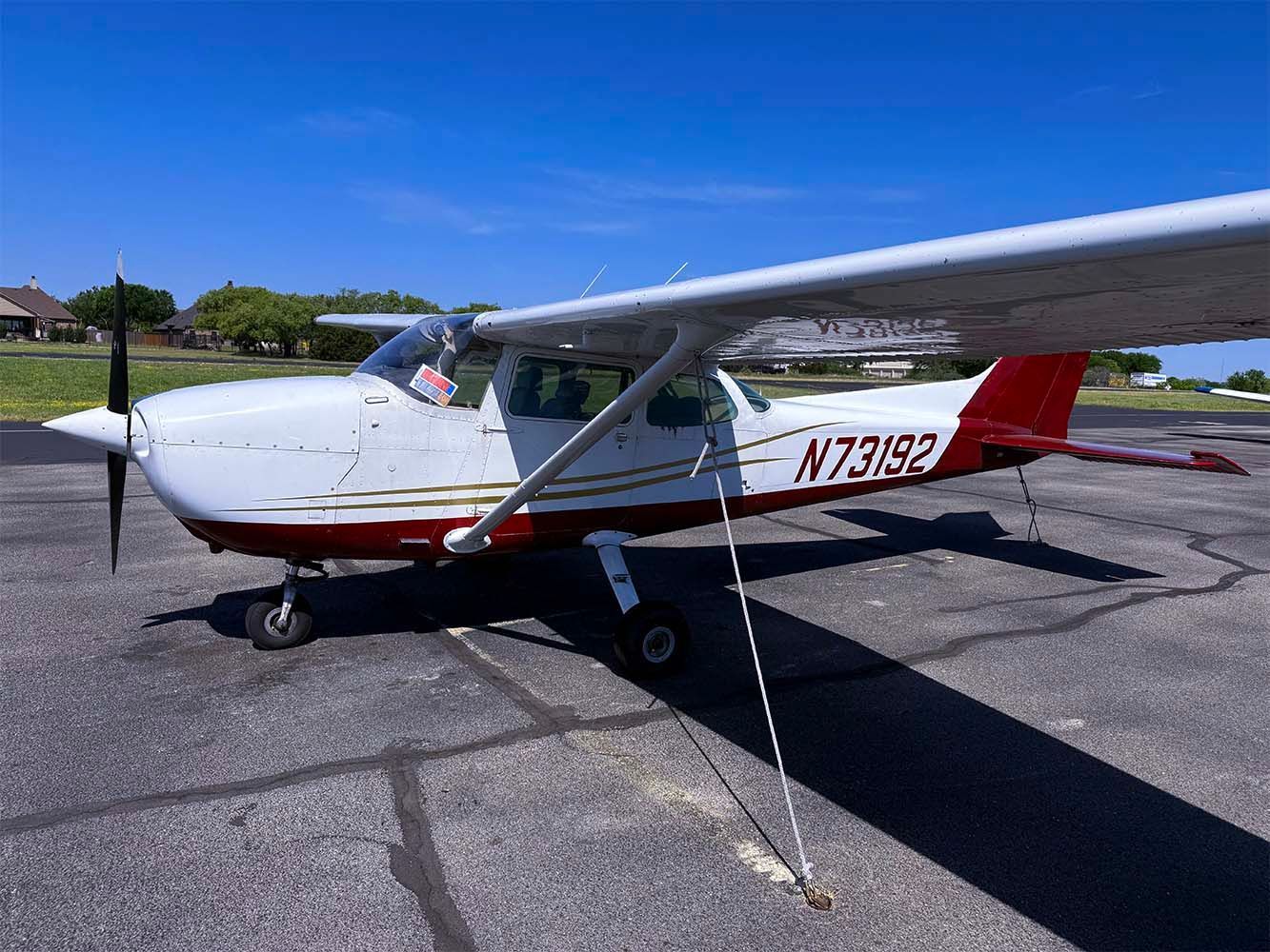 Single-engine trainer aircraft parked on the ramp under clear skies.