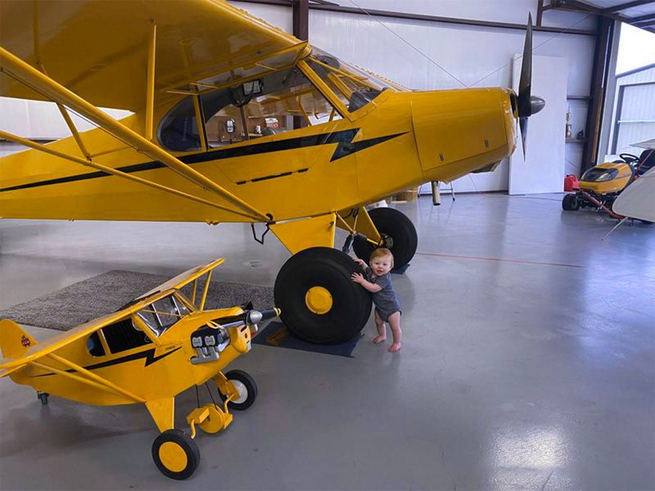 Yellow taildragger aircraft parked inside the hangar.