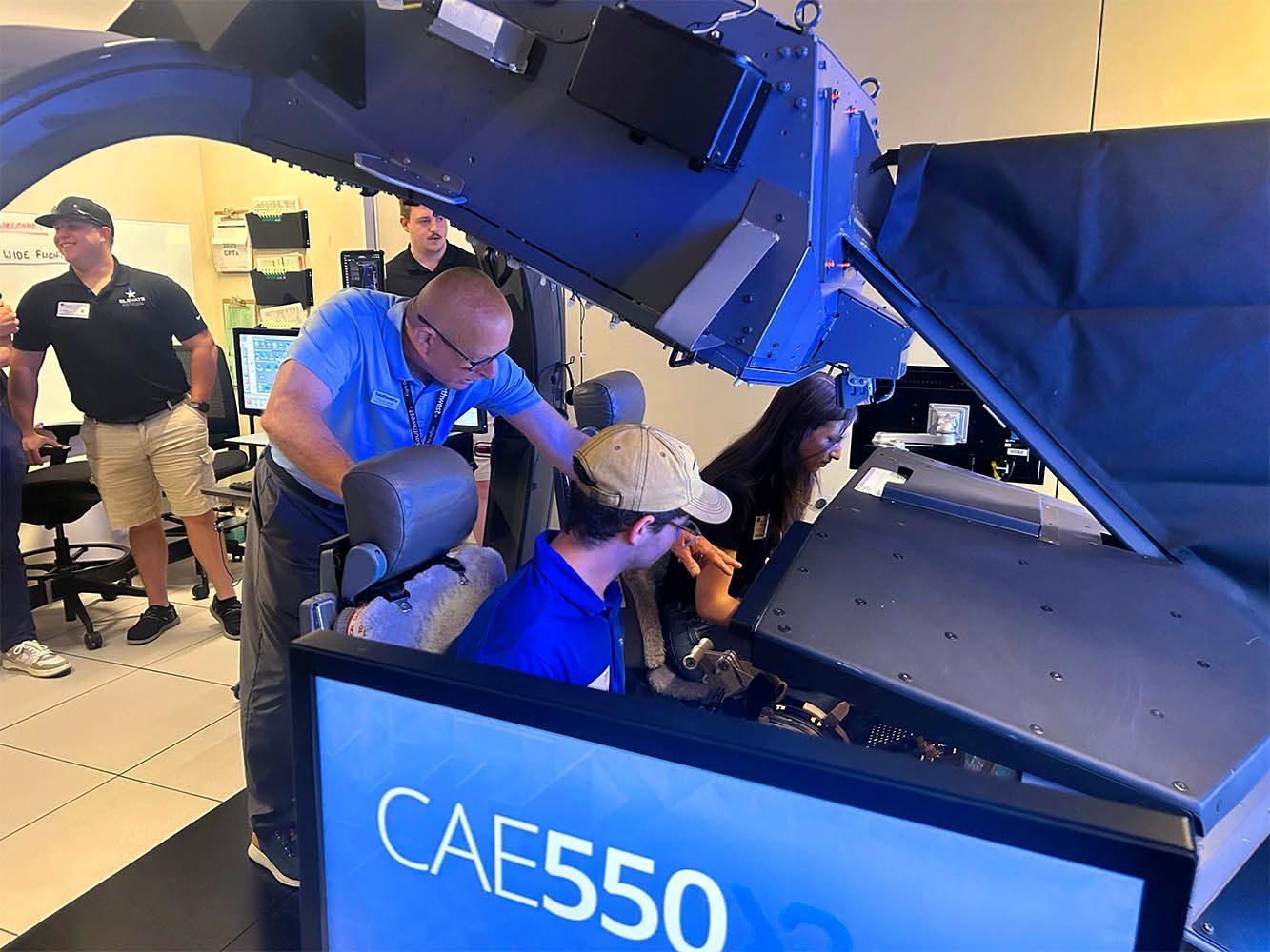 Aircraft maintenance crew working on engine components indoors.