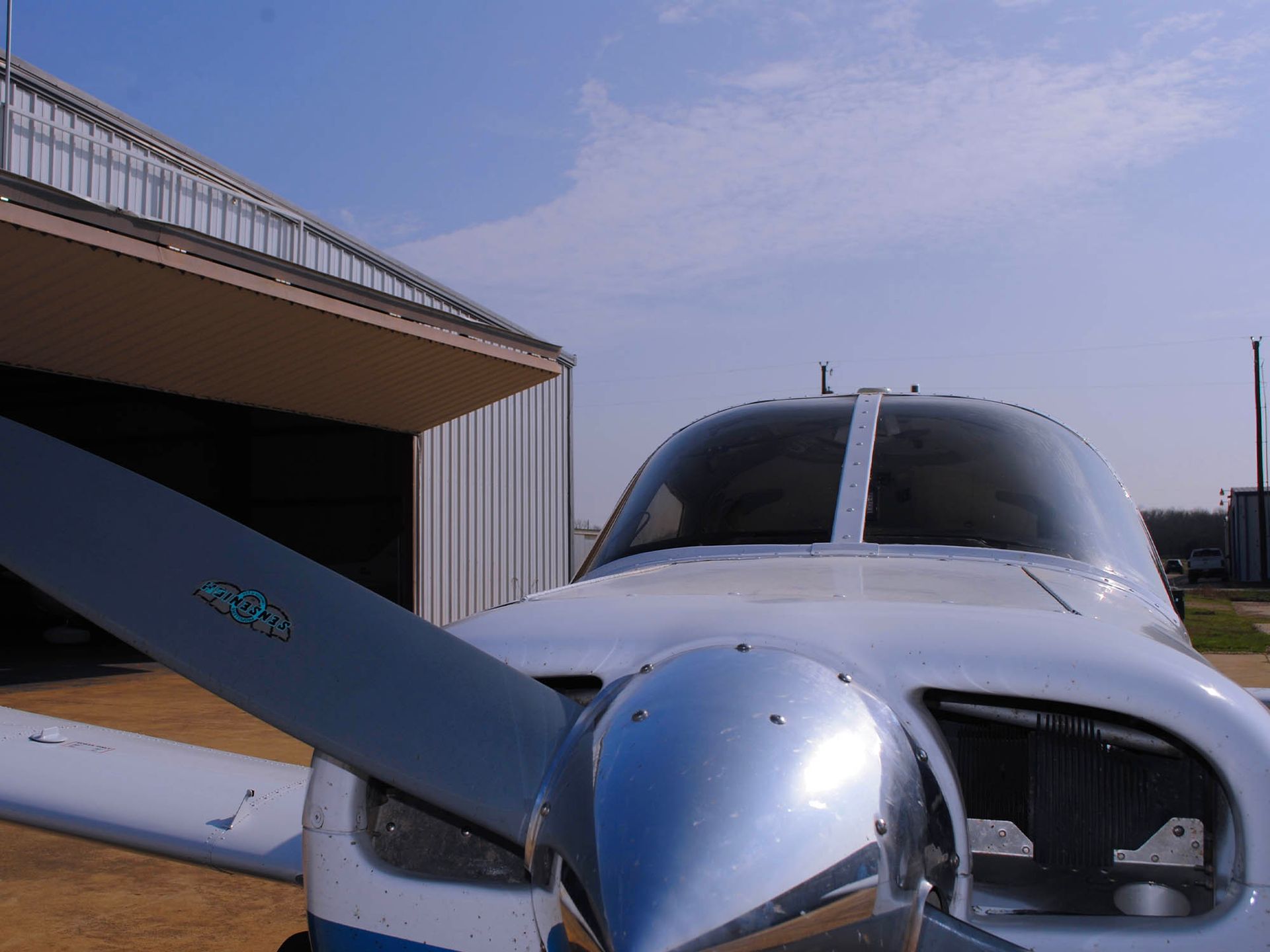Nose view of a twin-engine aircraft outside the hangar.