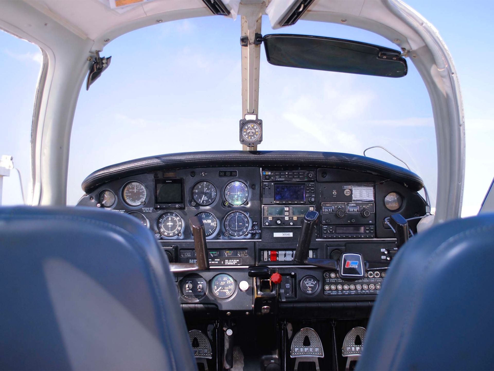 Cockpit interior of a single-engine aircraft with flight instruments visible.