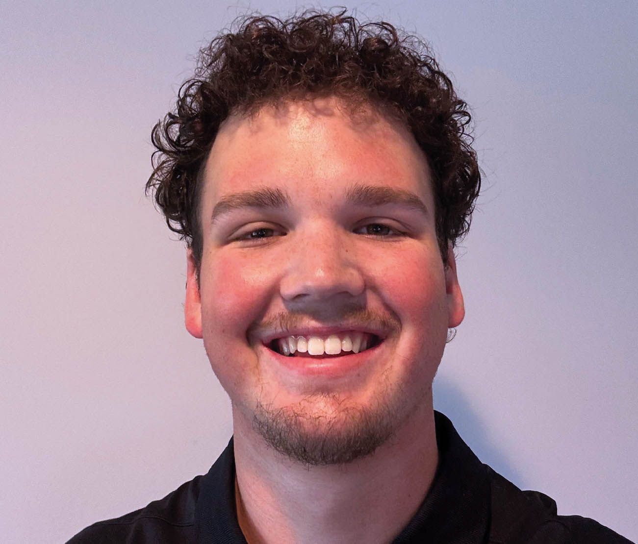 Student smiling in indoor portrait for aviation testimonial.