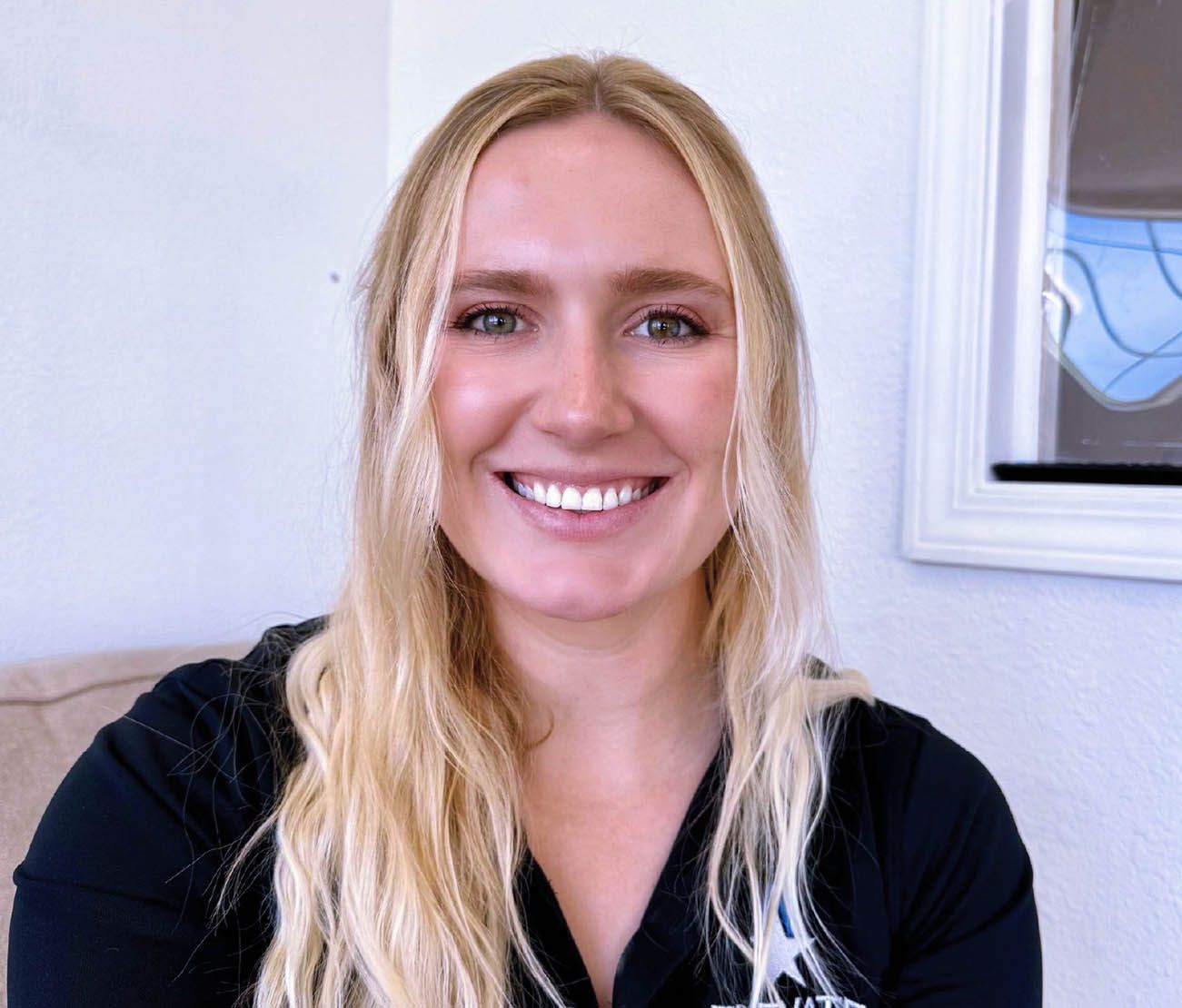 Student smiling indoors for aviation training testimonial portrait.