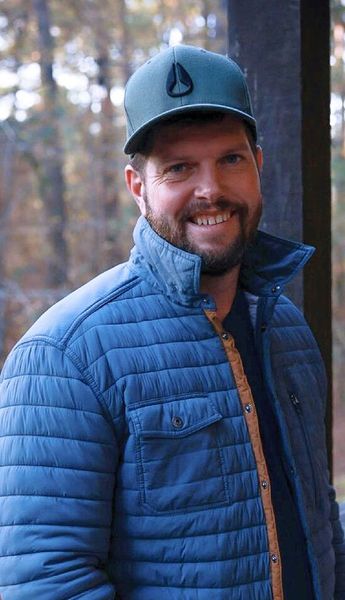 Man wearing cap outdoors for aviation leadership photo.