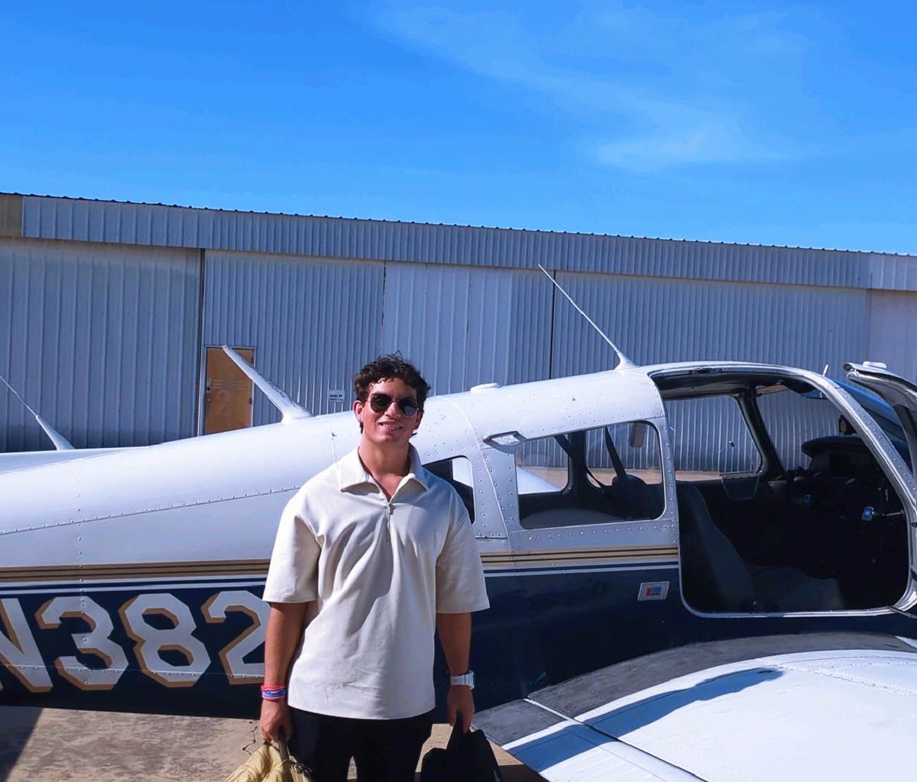Student standing next to single-engine aircraft for testimonial.