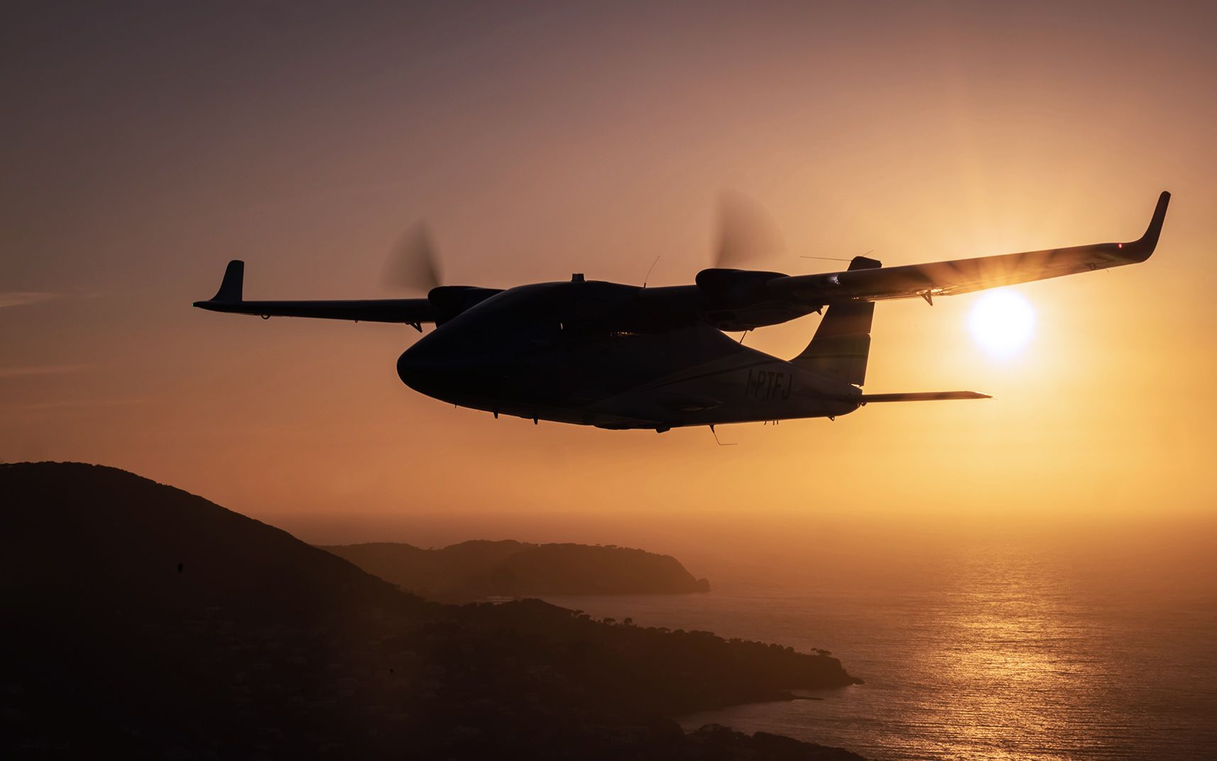 Aircraft flying at sunset above rolling hills.