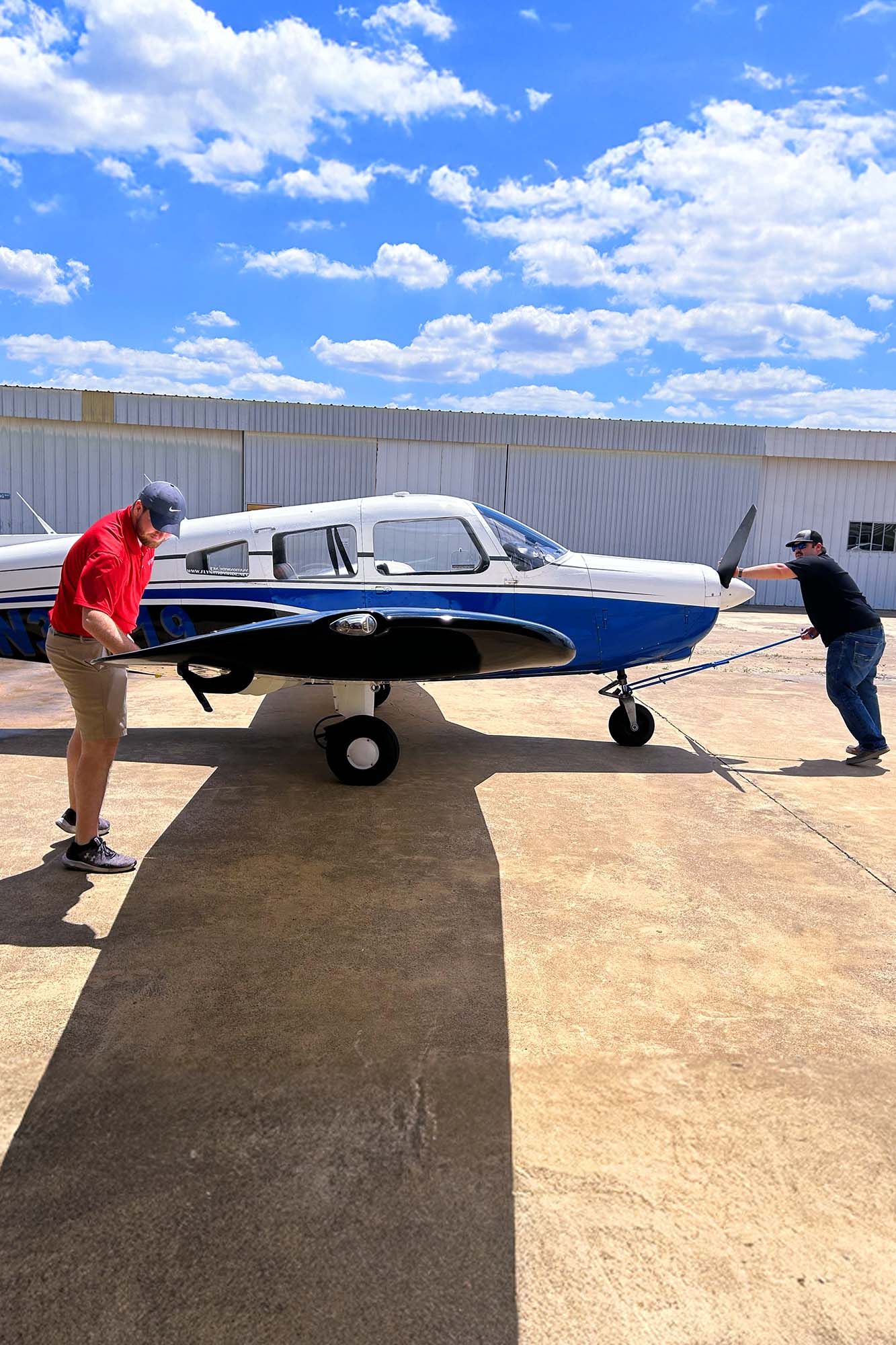 Airport ramp scene with aircraft and bright blue sky.