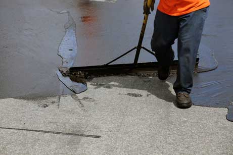 local contractor performing asphalt spread-sealcoating