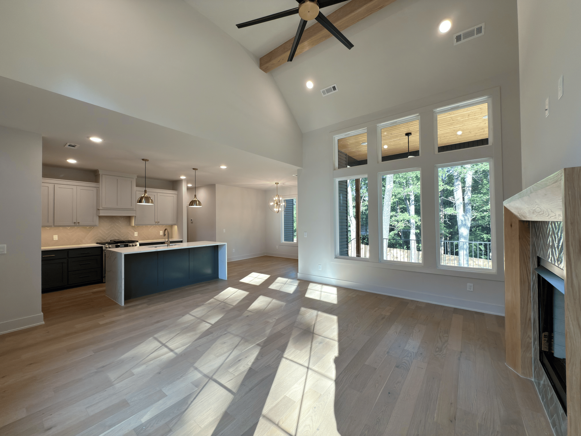 Library with built-in bookshelves, fireplace, seating area. Dark wood floor, white rug, and a patterned ceiling light.