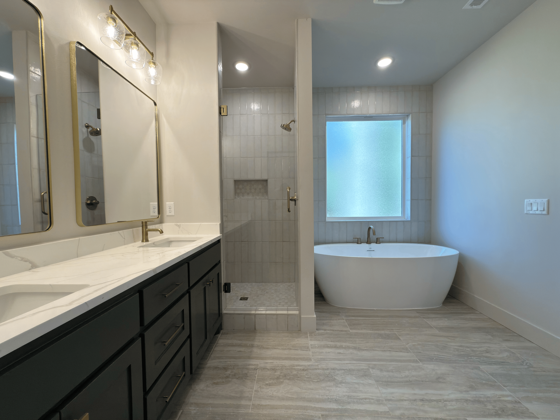 Elegant white bathroom with a tub, chandelier, and landscape view.