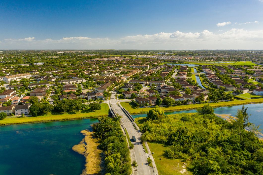 An aerial view of a bridge over a lake in a residential area.
