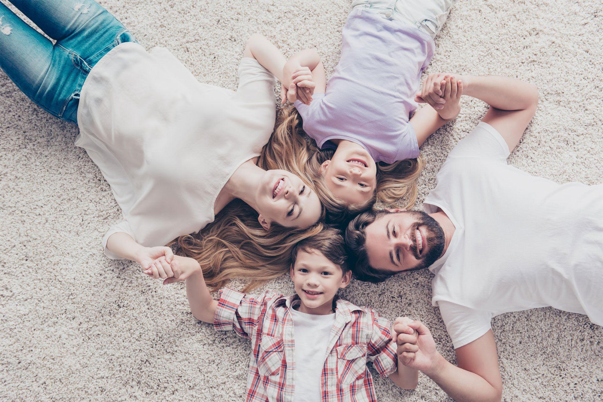 Happy Family Lying On Carpet — Gallatin, TN — Master’s Touch Cleaning and Restoration