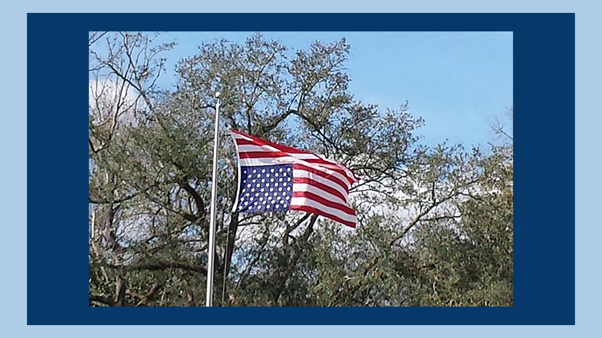 Photo of an U.S. flag flying upside down on a flagpole