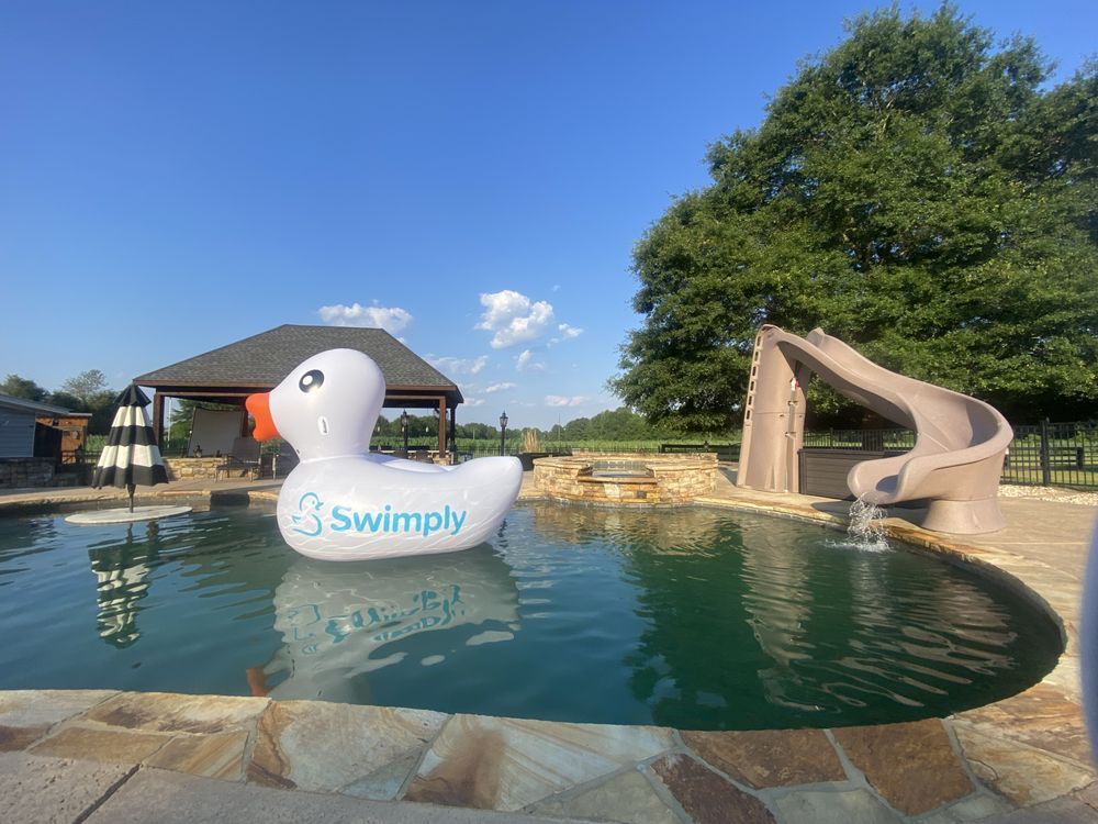 A large inflatable duck is floating in a swimming pool.