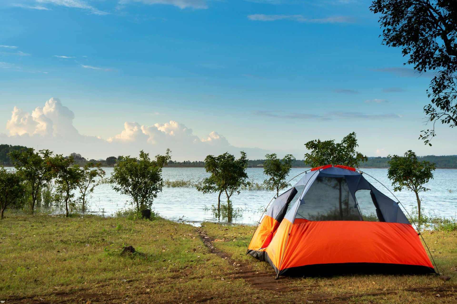 A tent is sitting on the shore of a lake.