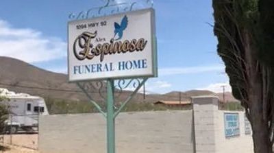 a sign for a funeral home with mountains in the background .