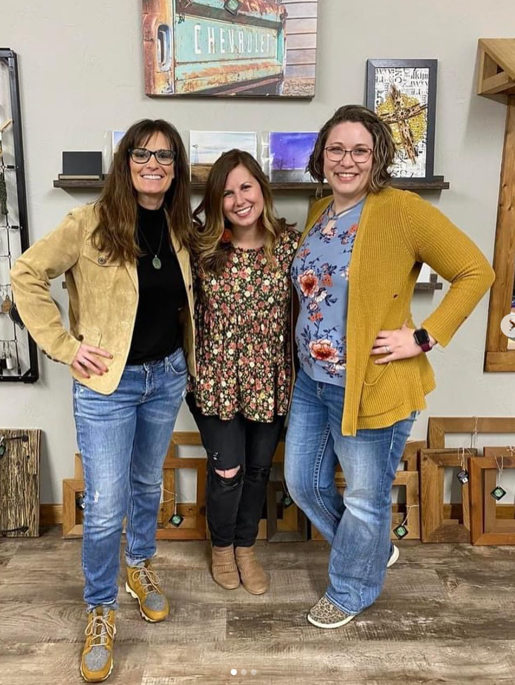 Three women are posing for a picture together in a room.