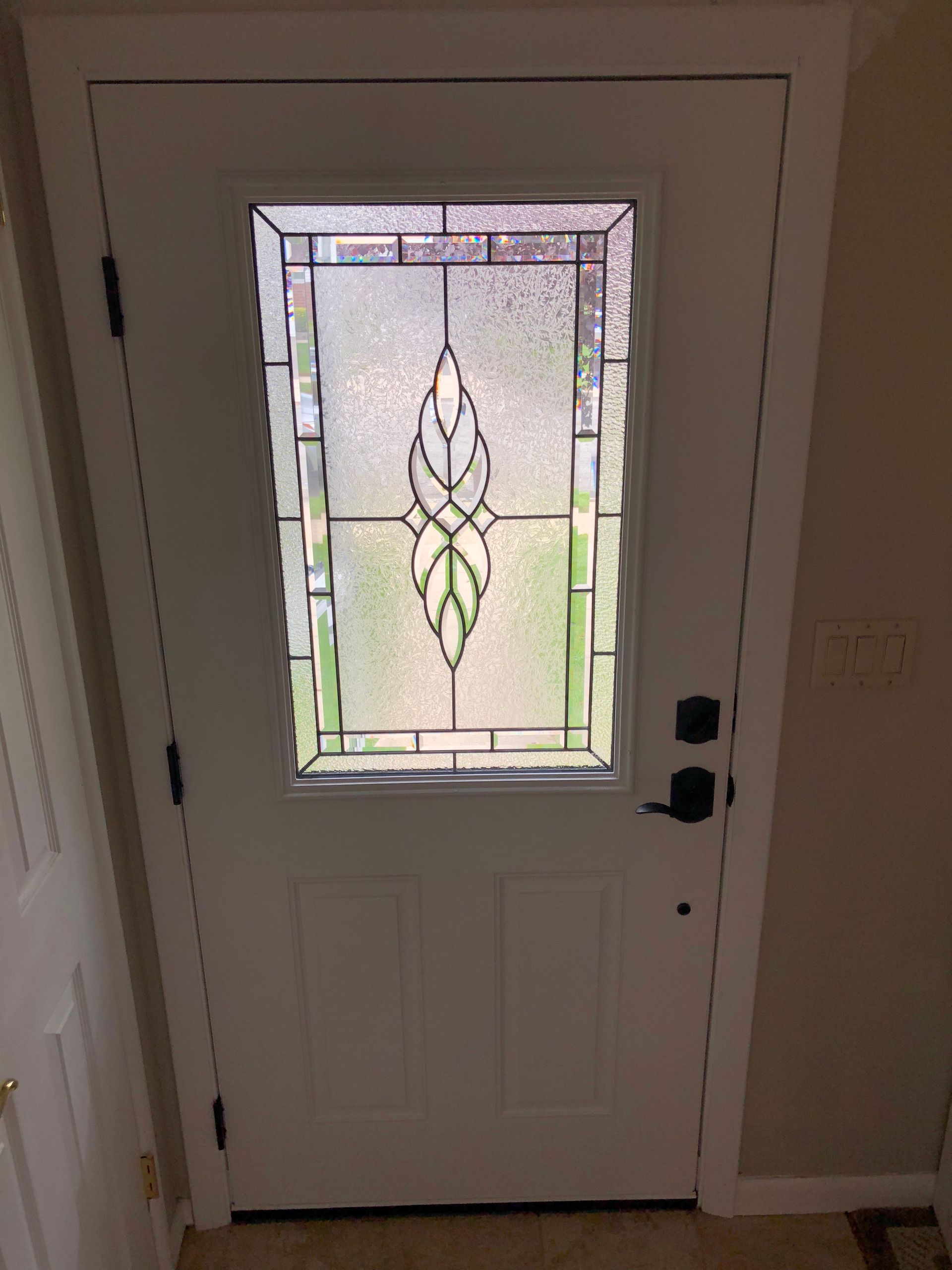 A white door with a stained glass window in it.