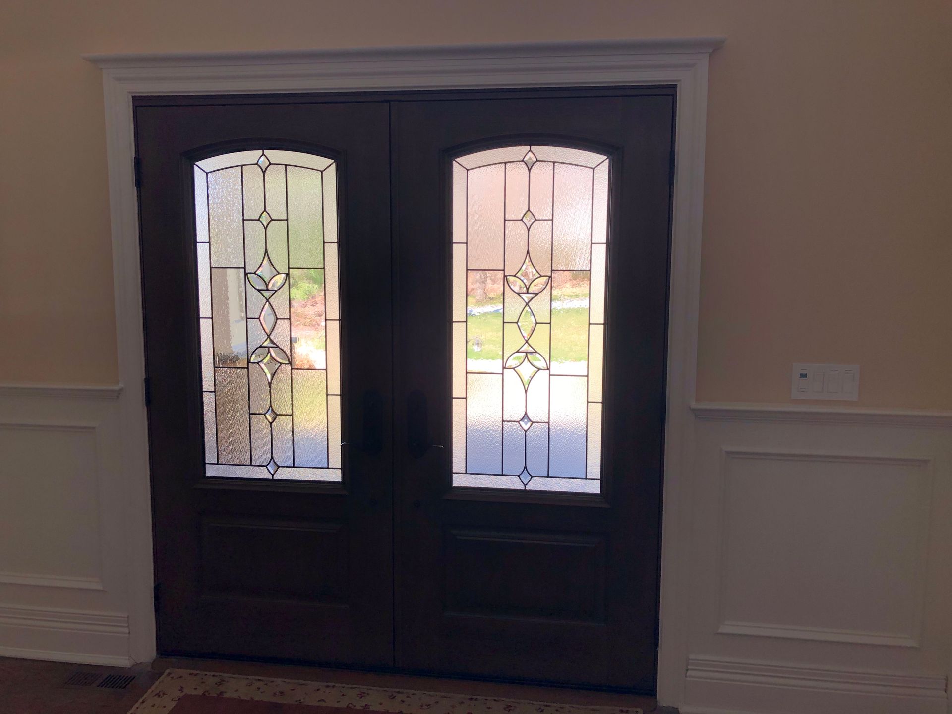 A pair of double doors with stained glass windows in a room.