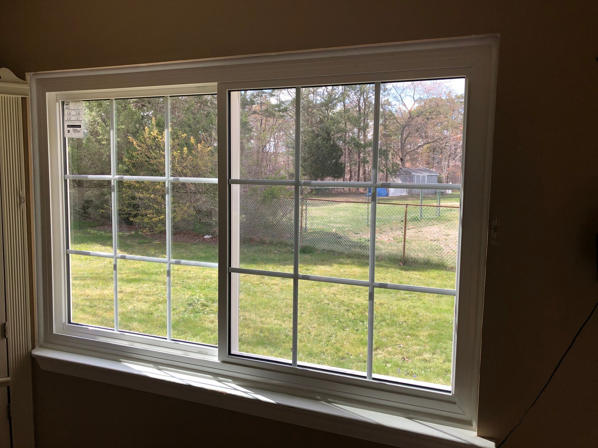 A large window with a view of a lush green field.