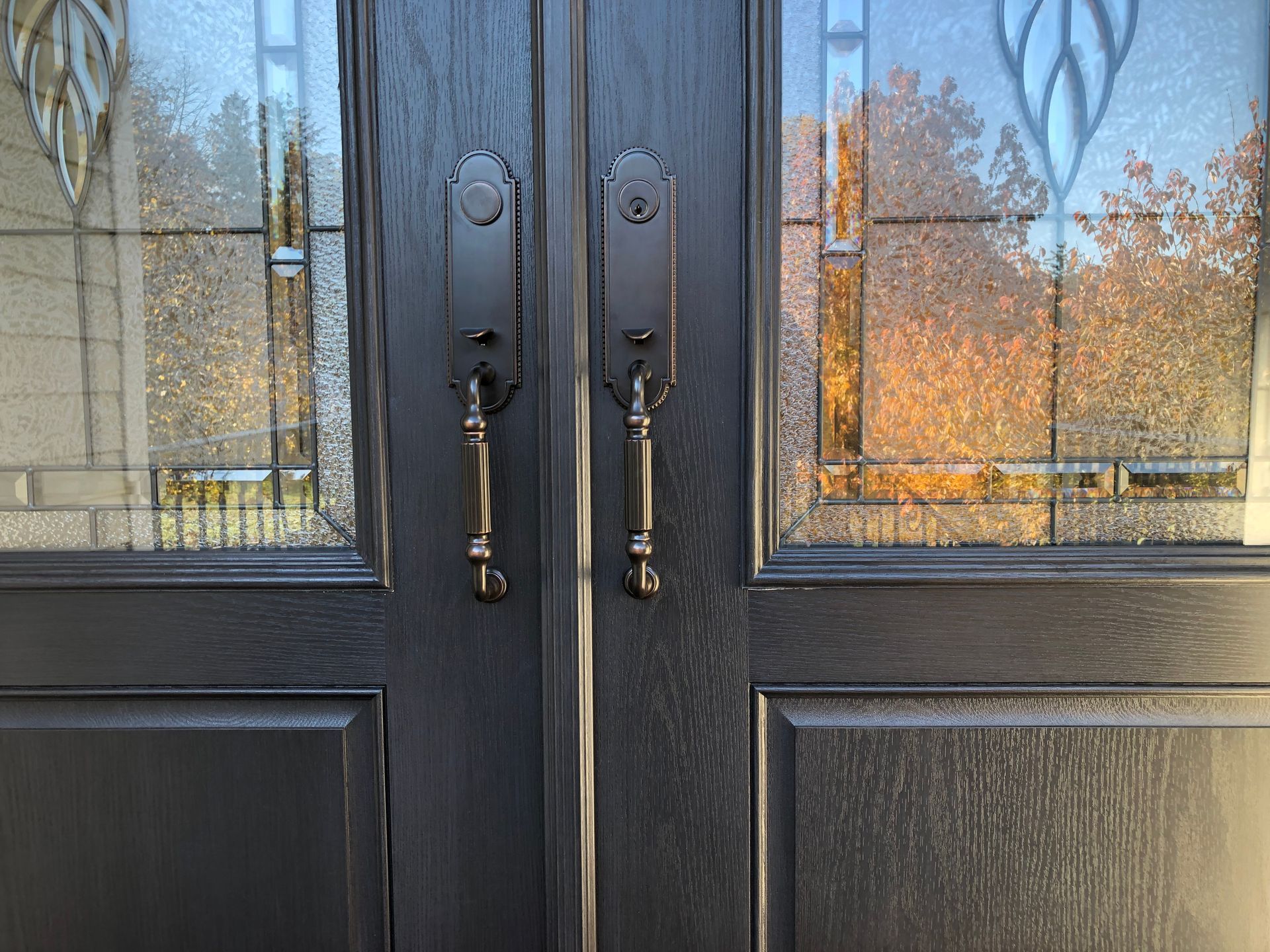 A close up of a black door with stained glass