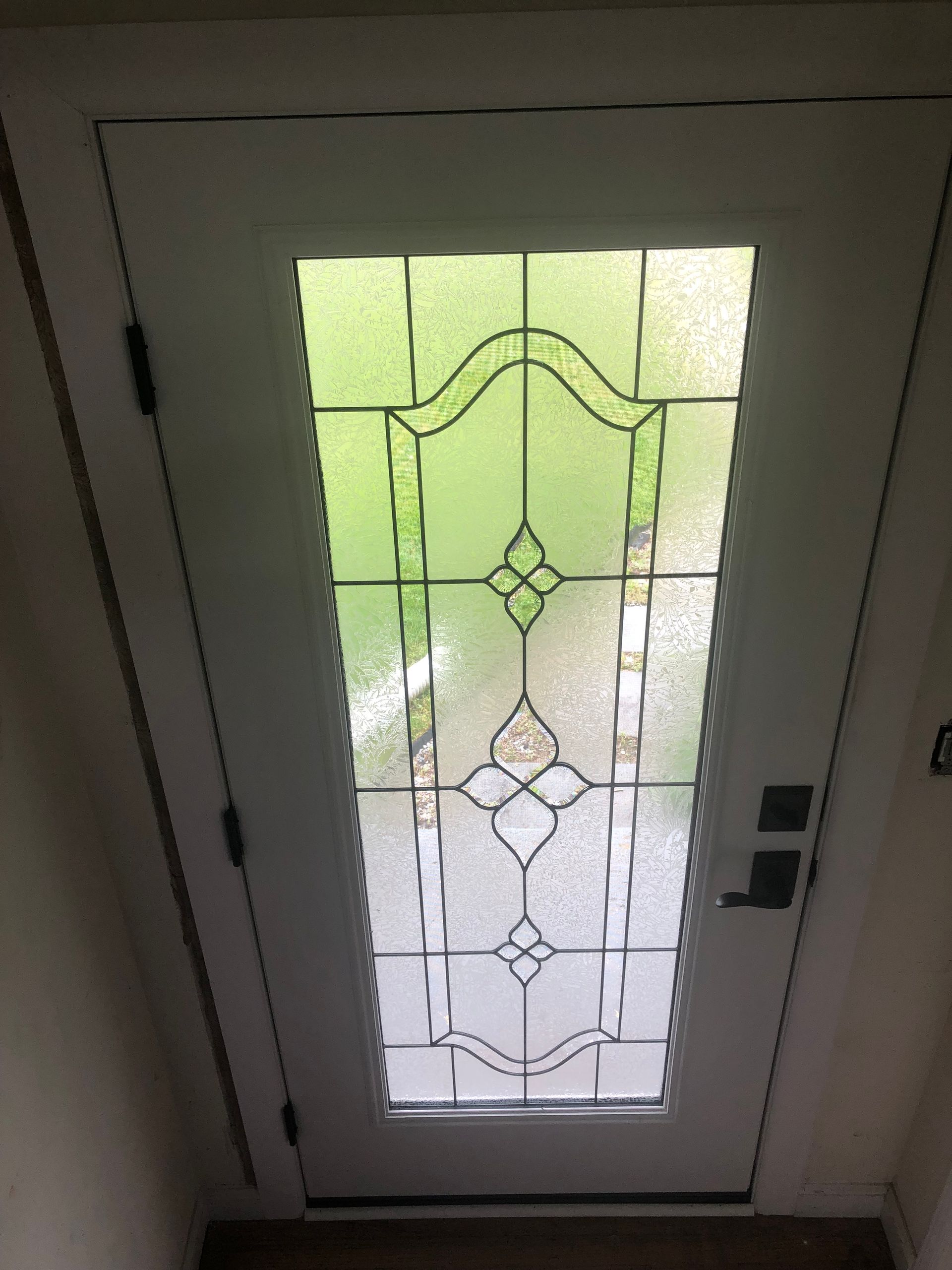 A white door with a stained glass window in it.