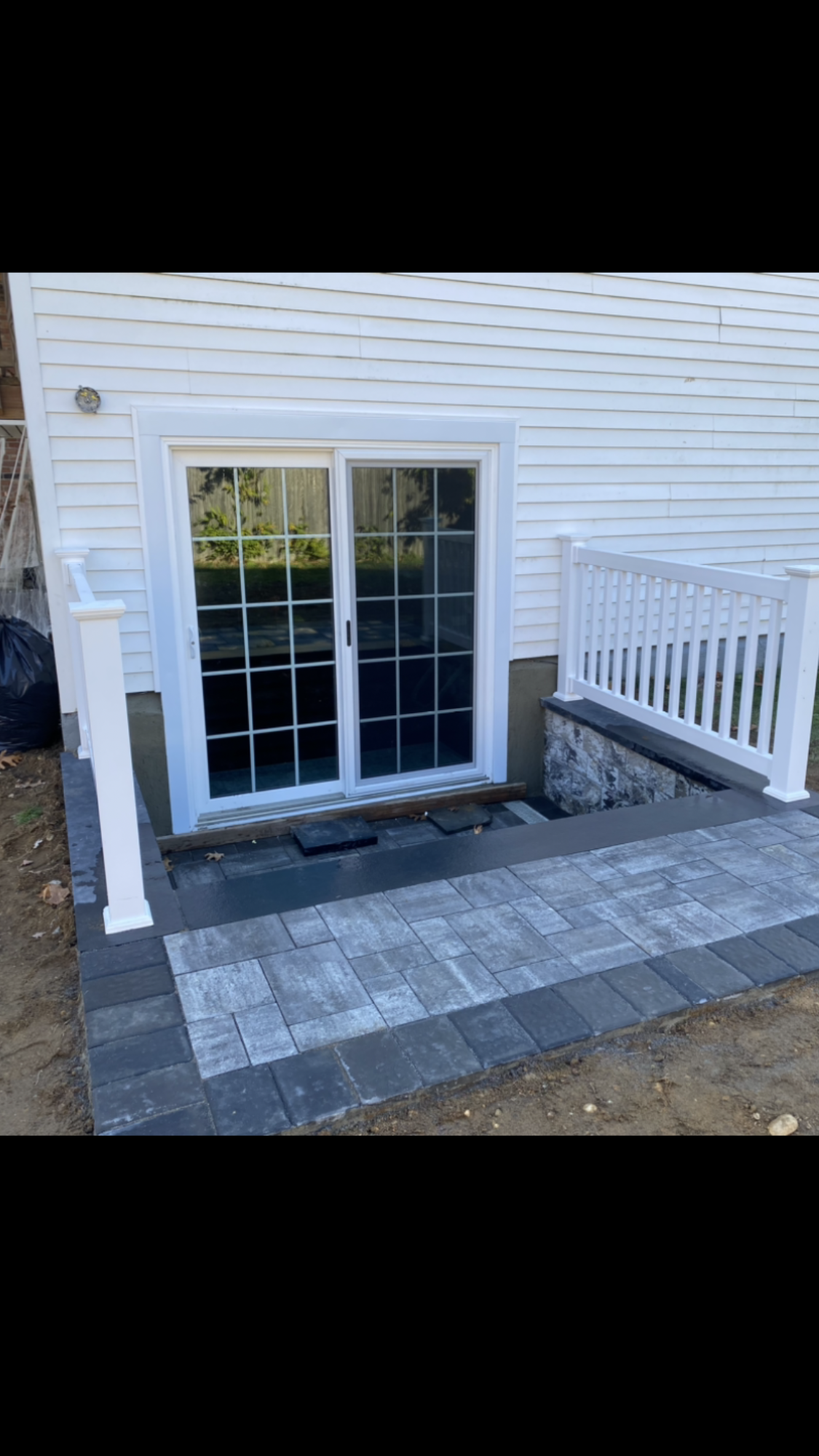 A white house with a sliding glass door and a patio.