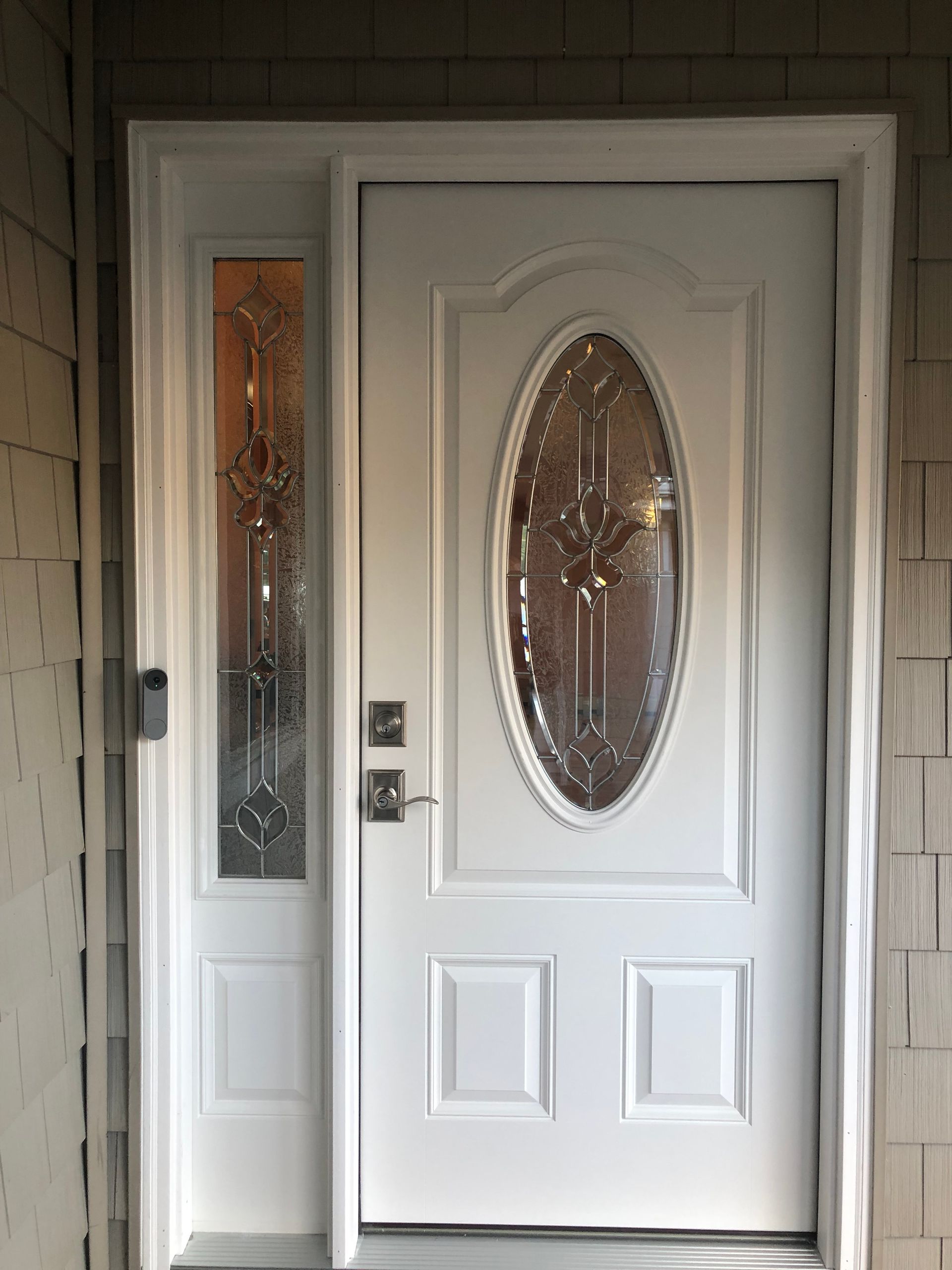 A white front door with a oval glass window