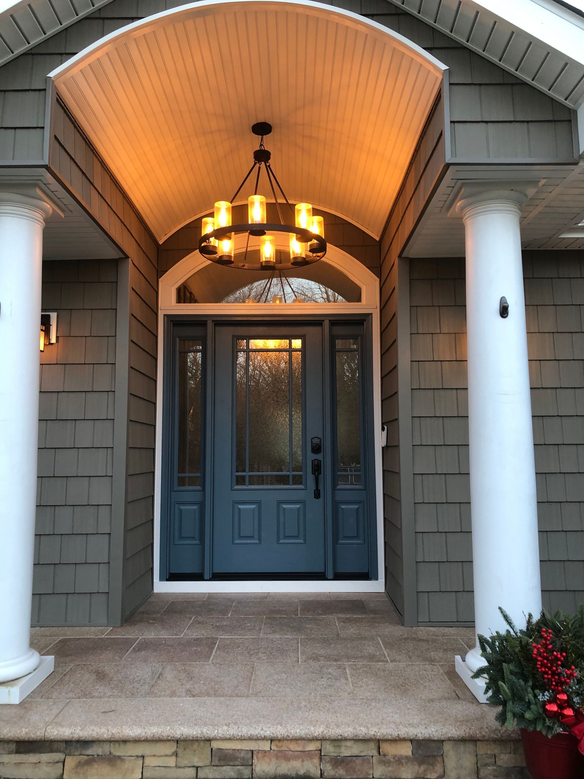 The front door of a house with a chandelier hanging from the ceiling