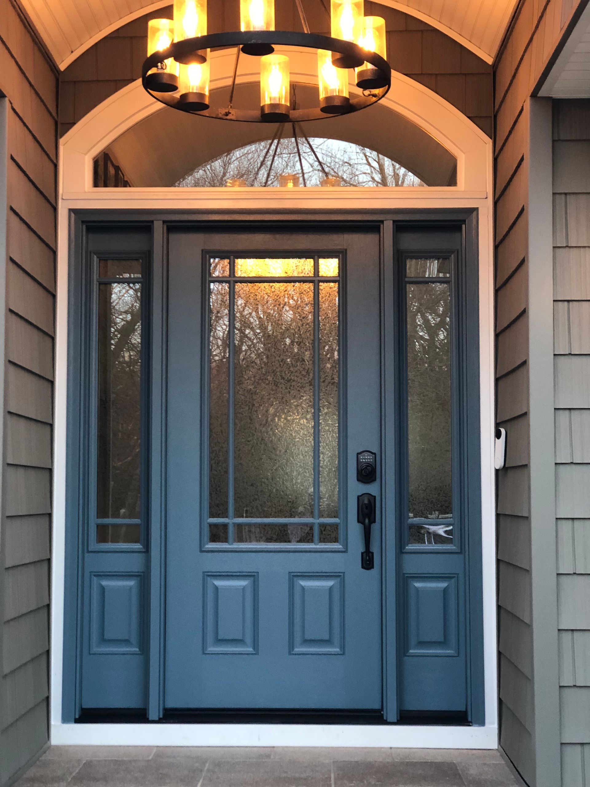 A blue door with a chandelier above it