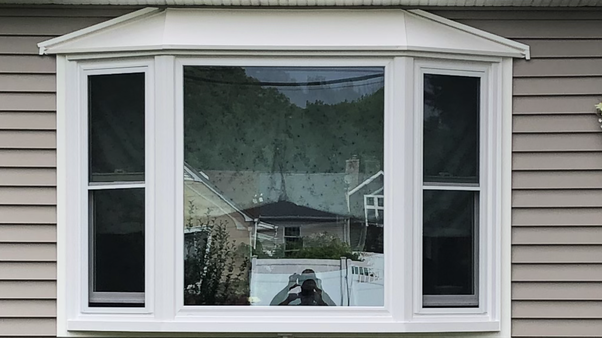 A white bay window on the side of a house.
